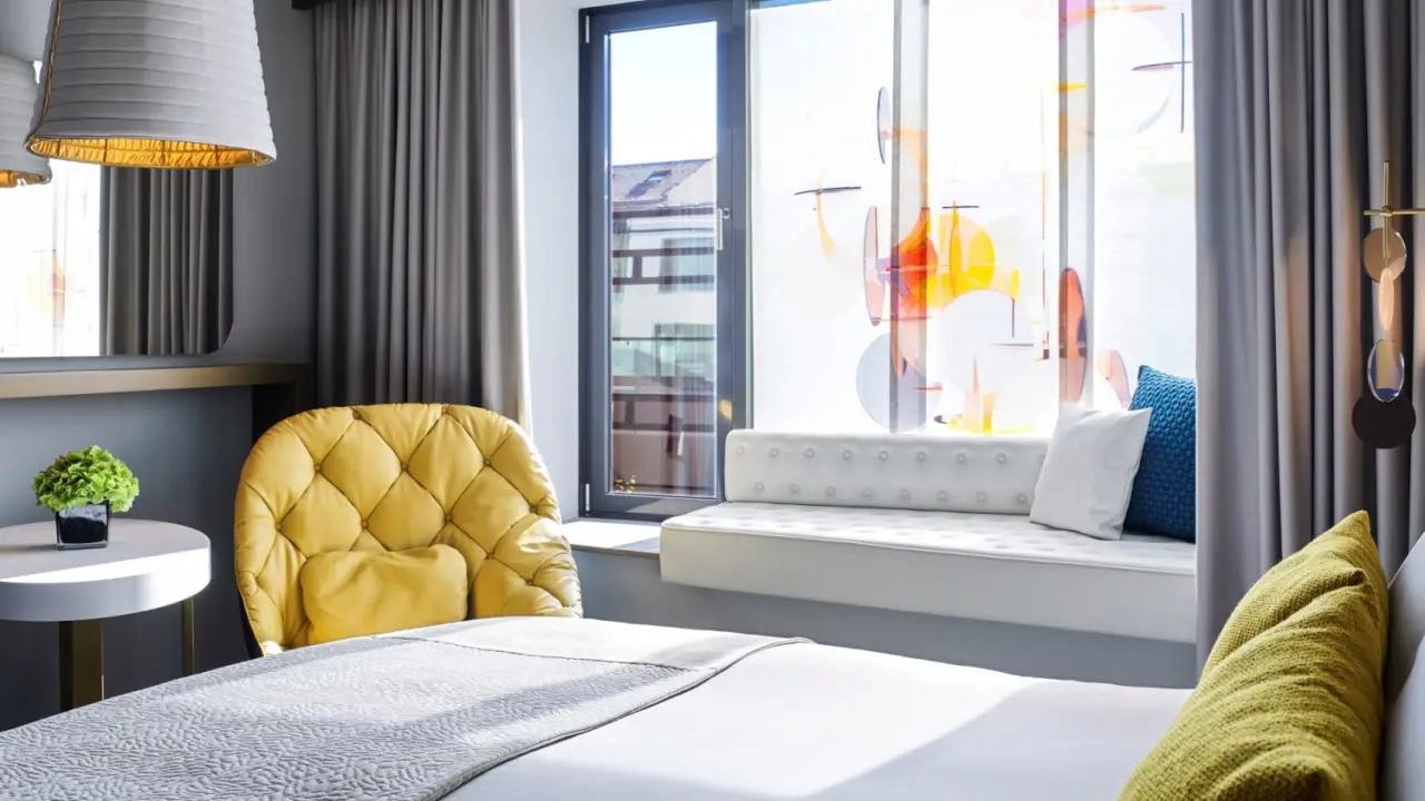 Sofitel Munich Bayerpost in München – Helles Hotelzimmer mit gemütlichem Bett und Fensterblick | Wellnesshotel Bayern