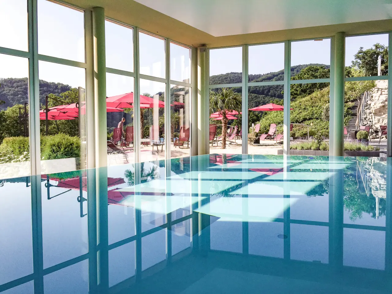 Parkhotel Krähennest in Löf – Heller Innenpool mit Blick auf die Sonnenterrasse | Wellnesshotel Mosel