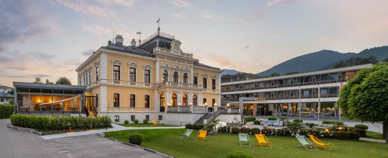 Villa Seilern Vital Resort in Bad Ischl – Hotelanlage bei Sonnenuntergang mit Garten und Liegen | Wellnesshotel Salzkammergut