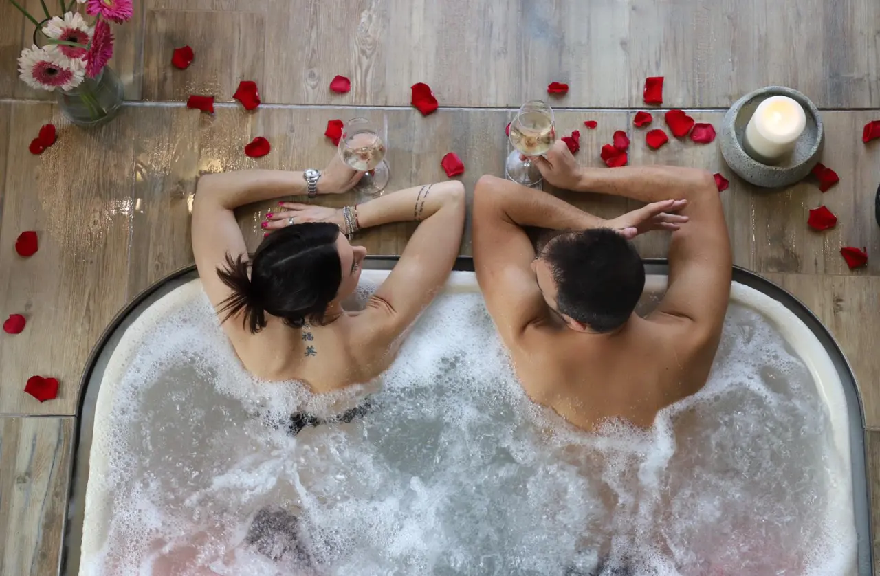 Ca 'Barbini Resort in Garda – Paar genießt ein romantisches Bad im Whirlpool mit Rosenblättern | Wellnesshotel Gardasee