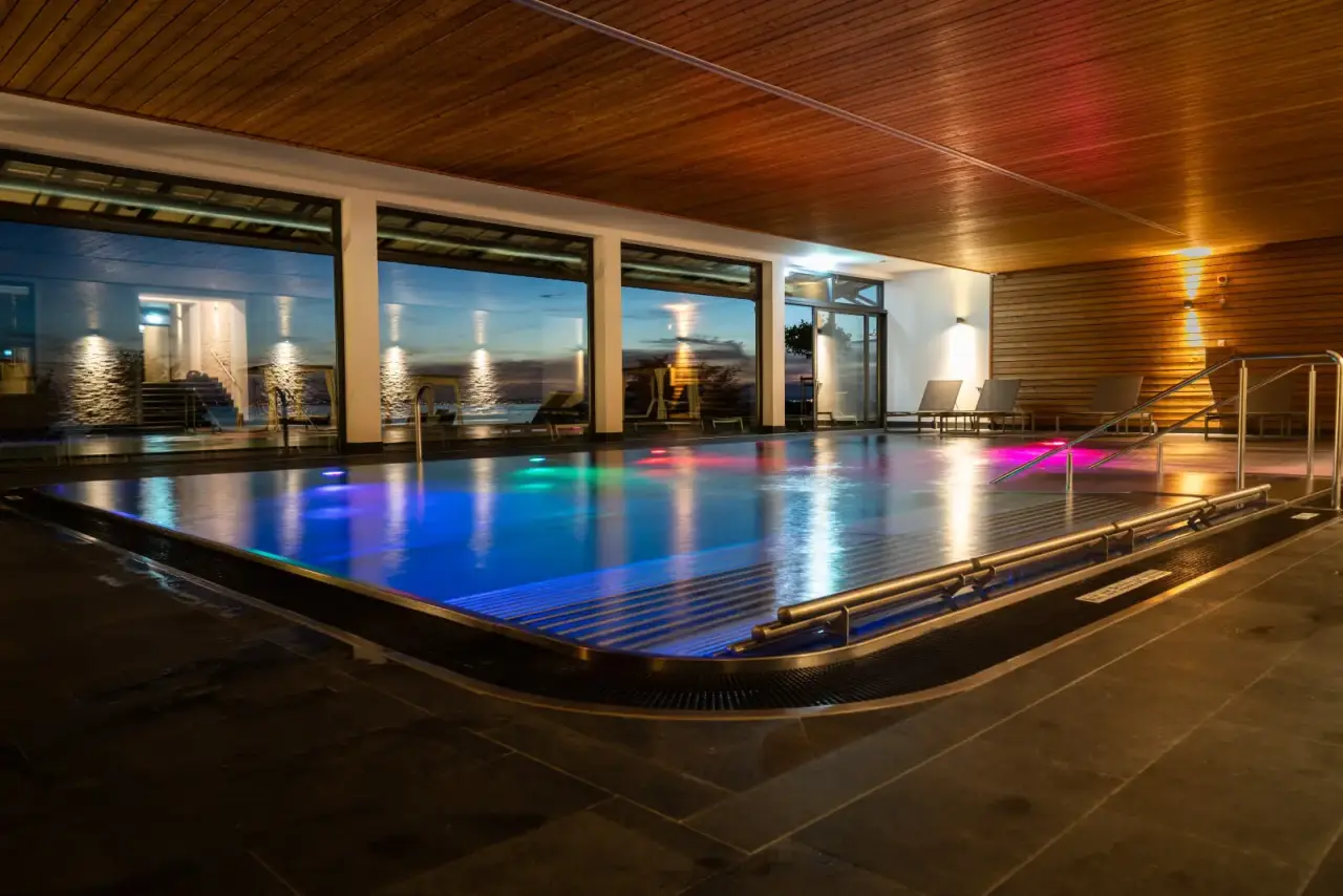 Bodensee-Hotel Sonnenhof in Kressbronn – Innenpool mit farbiger Beleuchtung und Seeblick | Wellnesshotel Bodensee