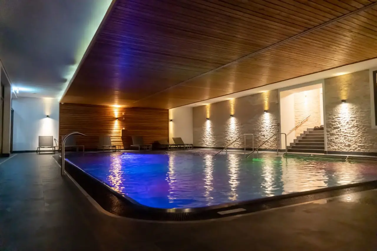 Bodensee-Hotel Sonnenhof in Kressbronn – Innenpool mit stimmungsvoller Beleuchtung und Ruheliegen | Wellnesshotel Bodensee
