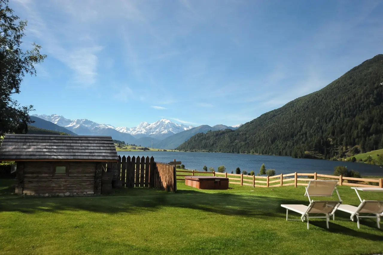 Hotel Ortlerspitz in Reschen – Garten mit Liegestühlen, Reschensee und Alpenpanorama | Wellnesshotel Vinschgau