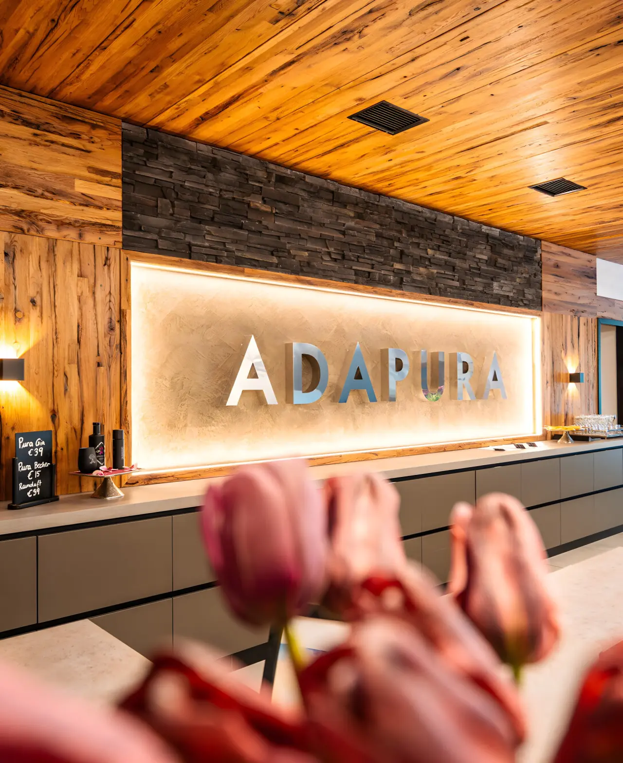 Hotel Adapura Wagrain in Wagrain – Beleuchtetes Hotellogo im Empfangsbereich | Wellnesshotel Salzburger Land