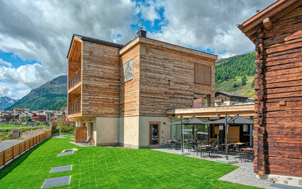 Hotel Vetta Alpine Relax in Livigno – Moderne Holzfassade mit grüner Wiese | Wellnesshotel Italienische Alpen