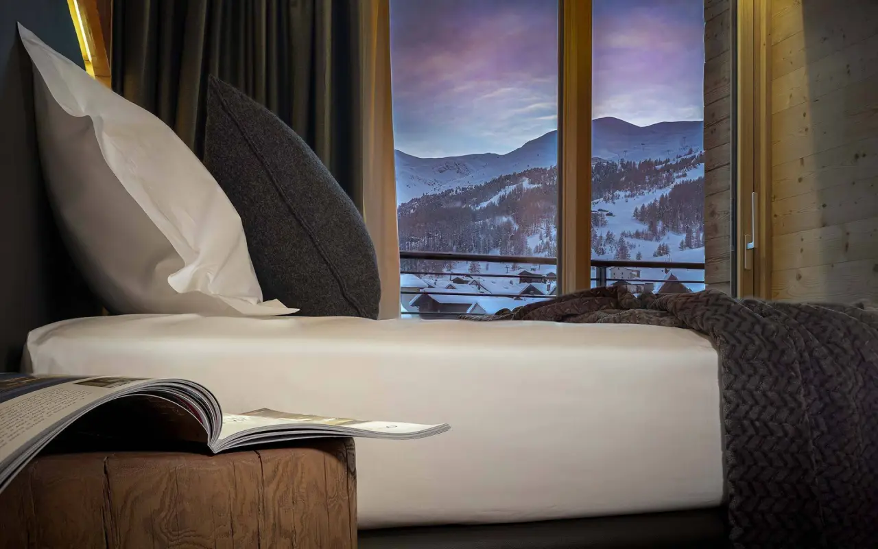 Hotel Vetta Alpine Relax in Livigno – Gemütliches Schlafzimmer mit Blick auf verschneite Berge | Wellnesshotel Italienische Alpen