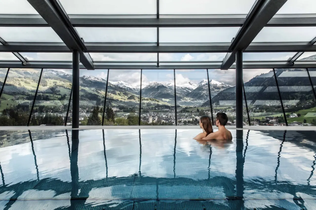 Lebenberger Schlosshotel in Kitzbühel – Paar im Infinity-Pool mit Alpenpanorama | Wellnesshotel Tirol