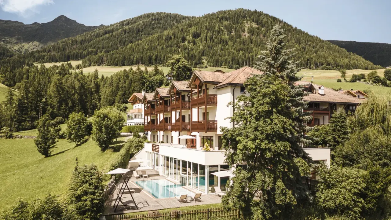 Falkensteiner Hotel & Spa Sonnenparadies in Bozen – Außenansicht mit Pool und Bergpanorama | Wellnesshotel Südtirol