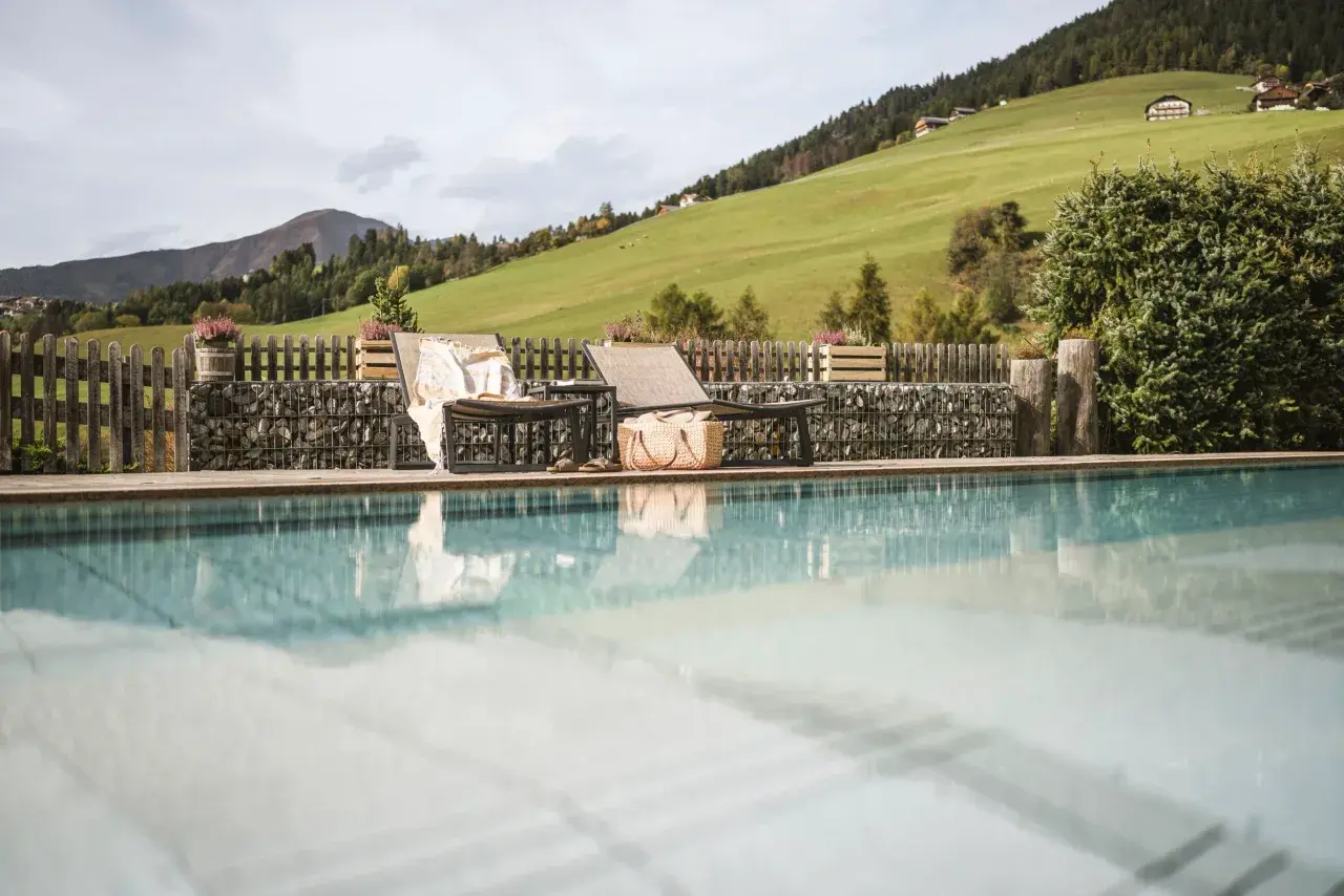 Falkensteiner Hotel & Spa Sonnenparadies in Terenten – Außenpool mit Liegen und Wiese | Wellnesshotel Pustertal