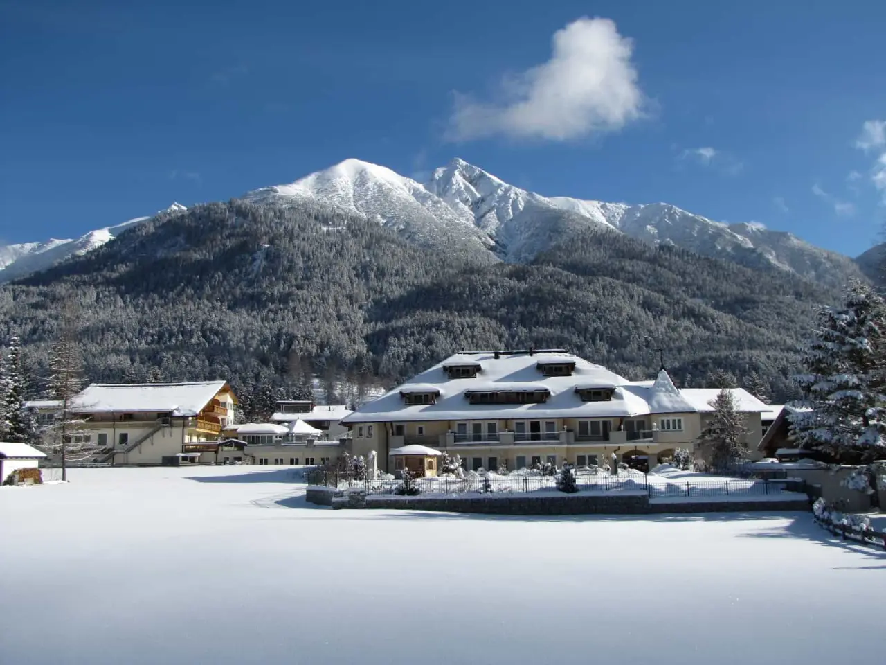 Wellnesshotel Schönruh in Seefeld – Hotelgebäude im Winter mit verschneiten Bergen | Wellnesshotel Tirol