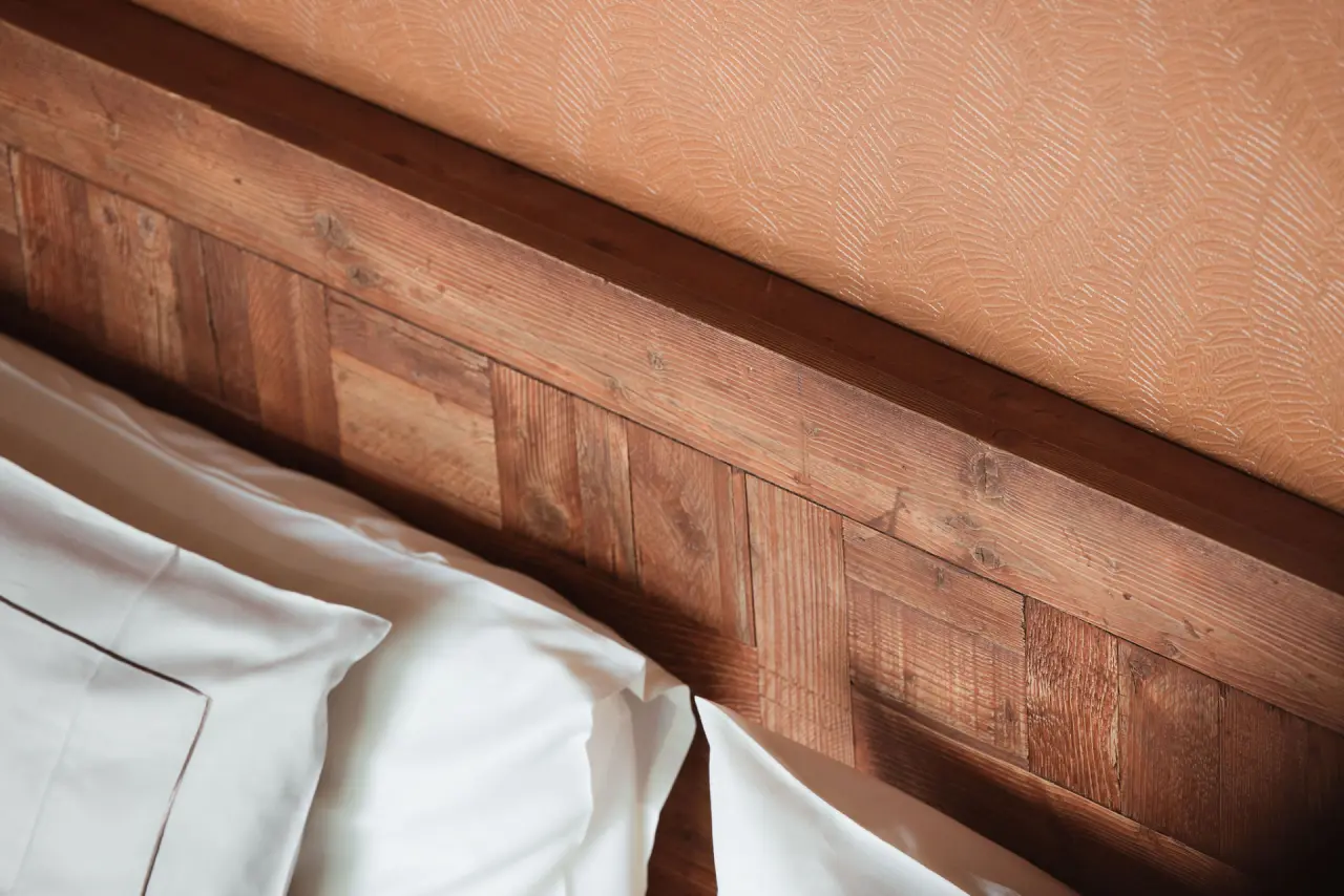 Valsana Hotel Arosa in Arosa – Detailansicht eines Hotelbettes mit Holzkopfteil | Wellnesshotel Graubünden