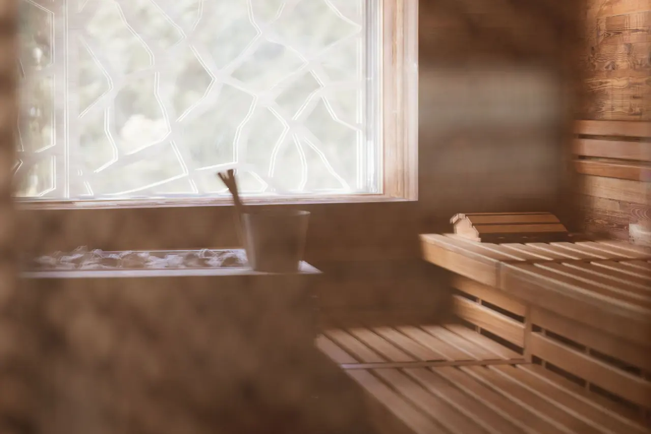 Valsana Hotel Arosa in Arosa – Detailansicht des Saunaofens und Holzbänke | Wellnesshotel Graubünden