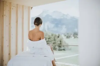 Hotel DIE WASNERIN in Bad Aussee – Frau im Bademantel mit Bergblick vom Balkon | Wellnesshotel Salzkammergut