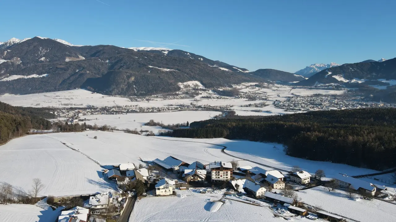 Appartements & Wellness Winkler in Bruneck – Winterlandschaft mit verschneiten Bergen und Dorf | Wellnesshotel Südtirol