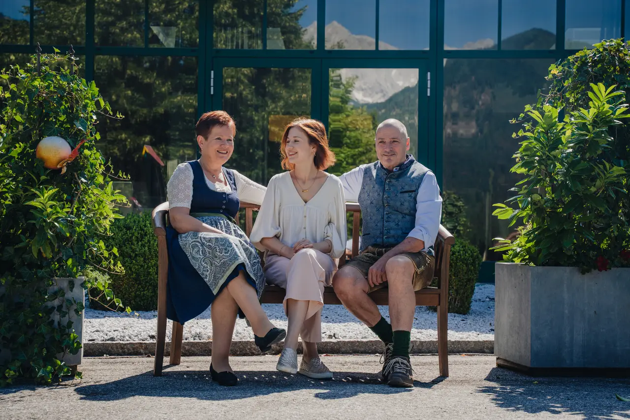 Relax & Wanderhotel Poppengut in Hinterstoder – Gäste auf einer Bank im Garten mit Bergblick | Wellnesshotel Oberösterreich