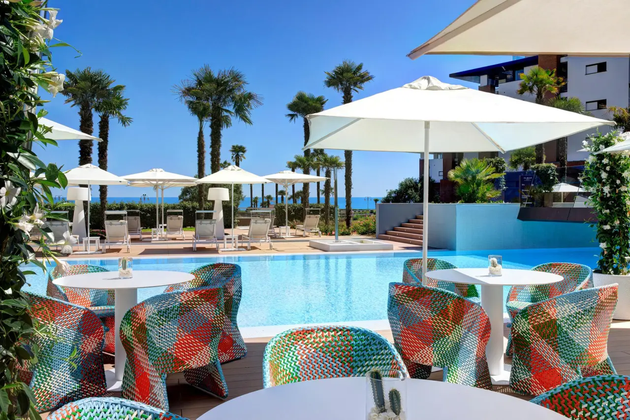 Almar Resort & Spa in Jesolo – Terrasse am Pool mit bunten Stühlen und Meerblick | Wellnesshotel Venetien