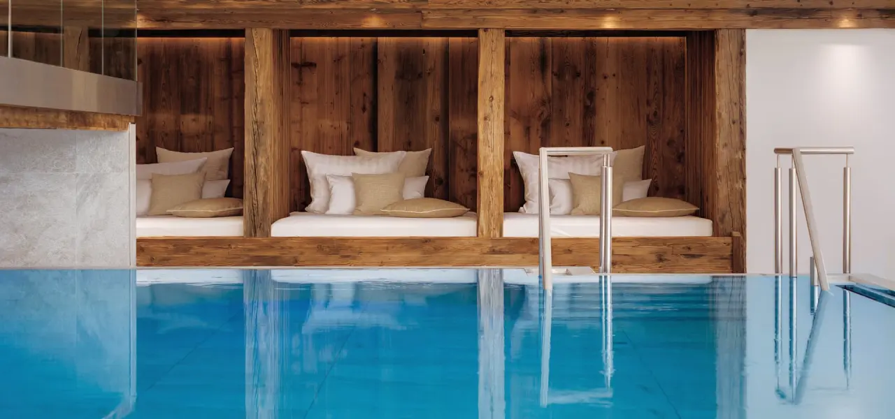 Wellnesshotel Adler Häusern in Häusern – Entspannungsbereich am Innenpool mit Holzliegen | Wellnesshotel Schwarzwald