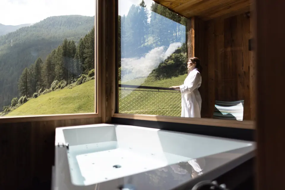 TONZHAUS in Senales – Frau im Bademantel mit Bergblick vom Whirlpool | Wellnesshotel Südtirol