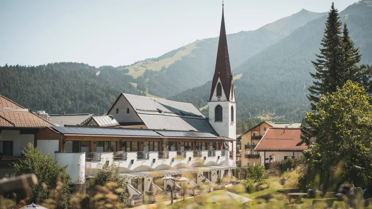 Hotel Kosterbräu in Seefeld – Außenansicht mit Kirche und Bergpanorama | Wellnesshotel Tirol