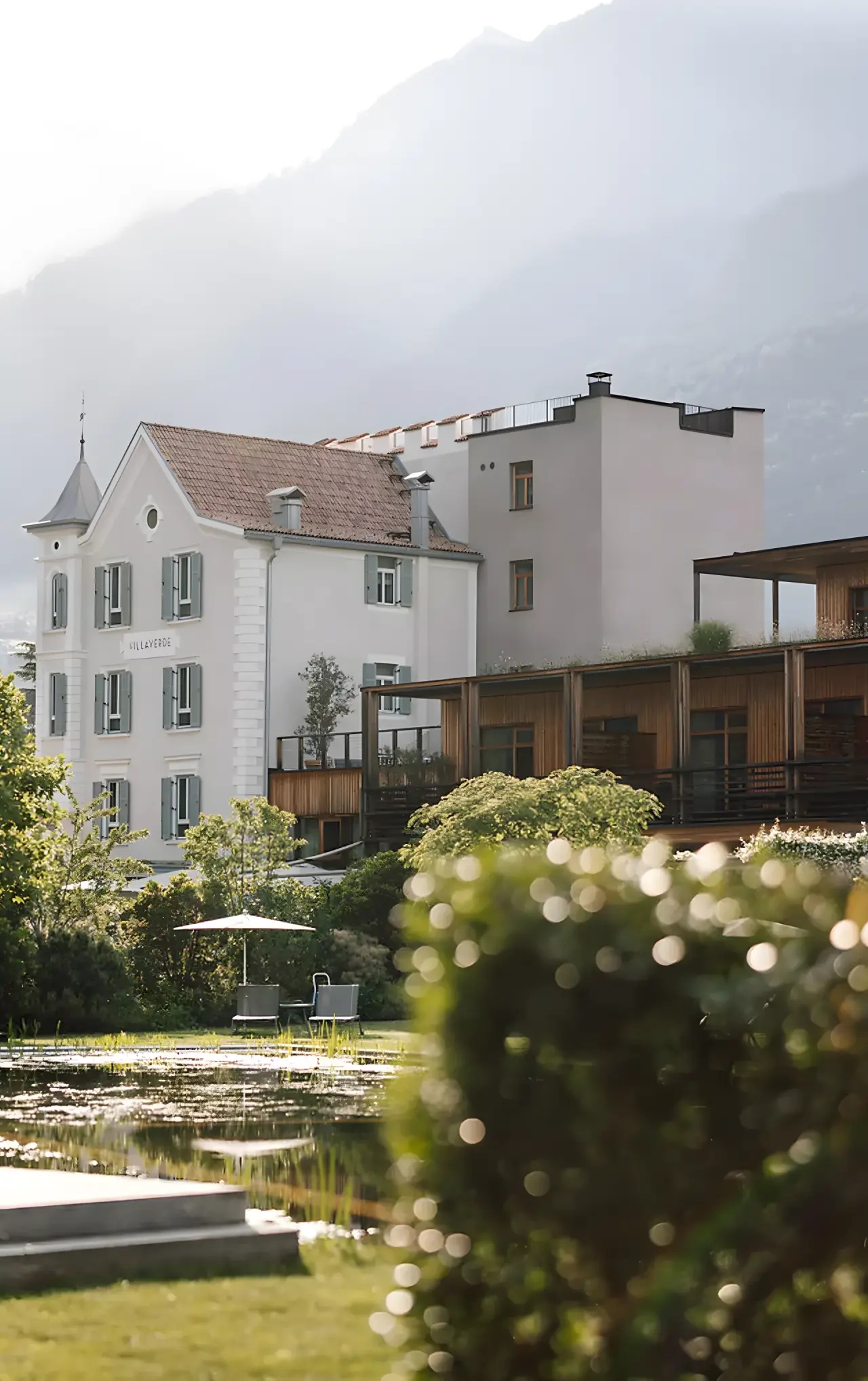 VillaVerde in Dorf Tirol – Hotelaußenansicht mit Naturteich und Bergpanorama | Wellnesshotel Südtirol