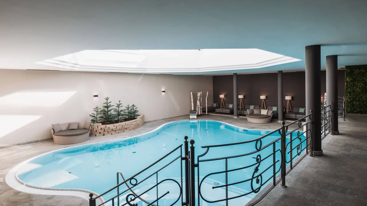 Montis – Active Nature Resort in Bruneck – Moderner Innenpoolbereich mit Liegemöglichkeiten | Wellnesshotel Südtirol