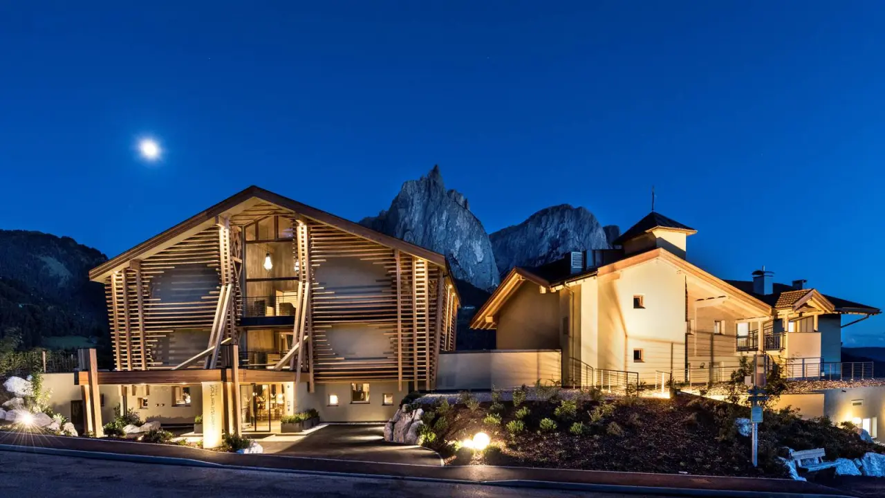 Vita Vital Hotel Valentinerhof in Kastelruth – Beleuchtete Hotelfassade bei Nacht mit Mond und Bergpanorama | Wellnesshotel Südtirol