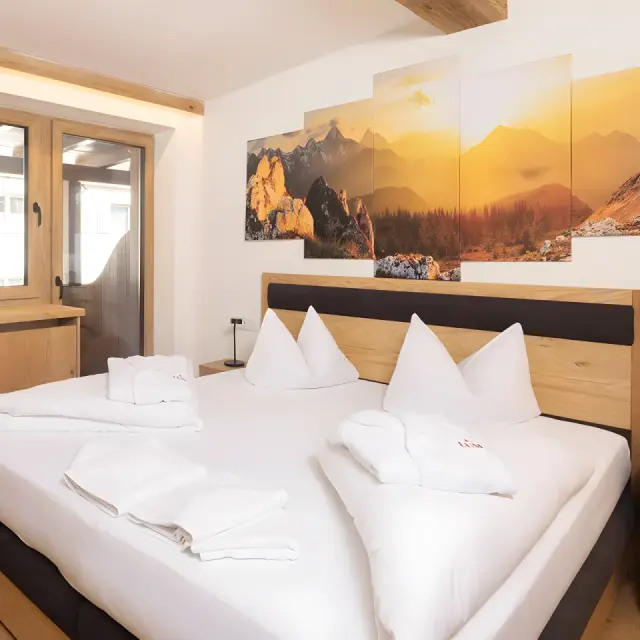 Hotel Brennerspitz in Neustift im Stubaital – Gemütliches Schlafzimmer mit Bergbildern | Wellnesshotel Stubaital