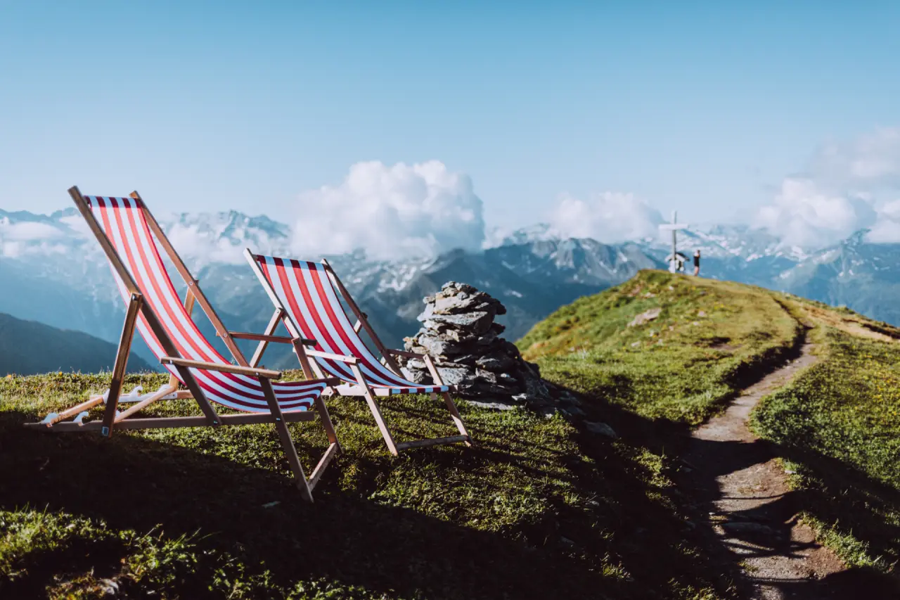 Das Alpenhaus Gasteinertal in Bad Hofgastein – Liegestühle auf Berggipfel mit Panoramablick | Wellnesshotel Gasteinertal