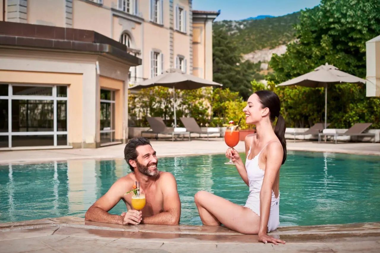 Bagni di Pisa in San Giuliano Terme – Paar genießt Cocktails im Außenpool mit Hotelblick | Wellnesshotel Toskana