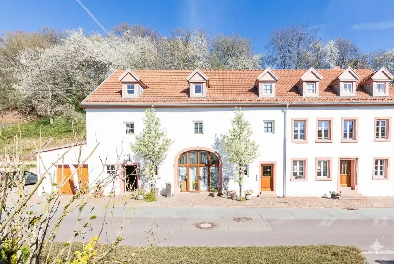 Hotel Erasmus in Trassem – Charmante Außenansicht mit blühenden Bäumen | Wellnesshotel Saarland