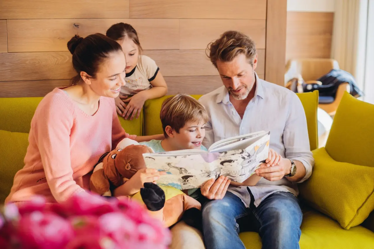 Hotel Reiters Finest Family in Bad Tatzmannsdorf – Familie liest gemeinsam im gemütlichen Hotelzimmer | Wellnesshotel Burgenland