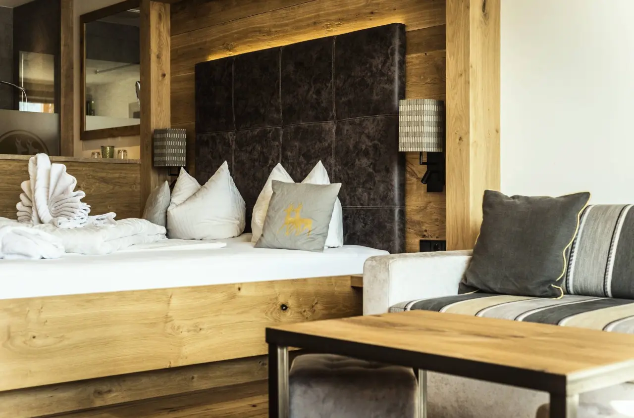 Hotel Rehbach Ruhehotel und Naturresort in Oberjoch – Gemütliches Doppelbett mit Holzverkleidung | Wellnesshotel Allgäu