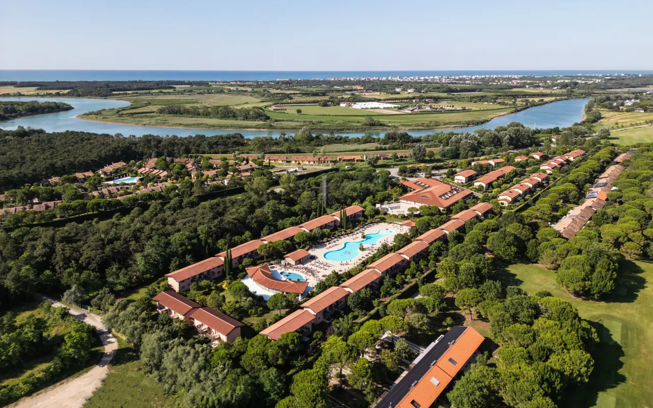 Green Village Resort 4 star Lignano in Lignano Sabbiadoro – Luftaufnahme des Resorts mit Pool und Fluss | Wellnesshotel Friaul-Julisch Venetien