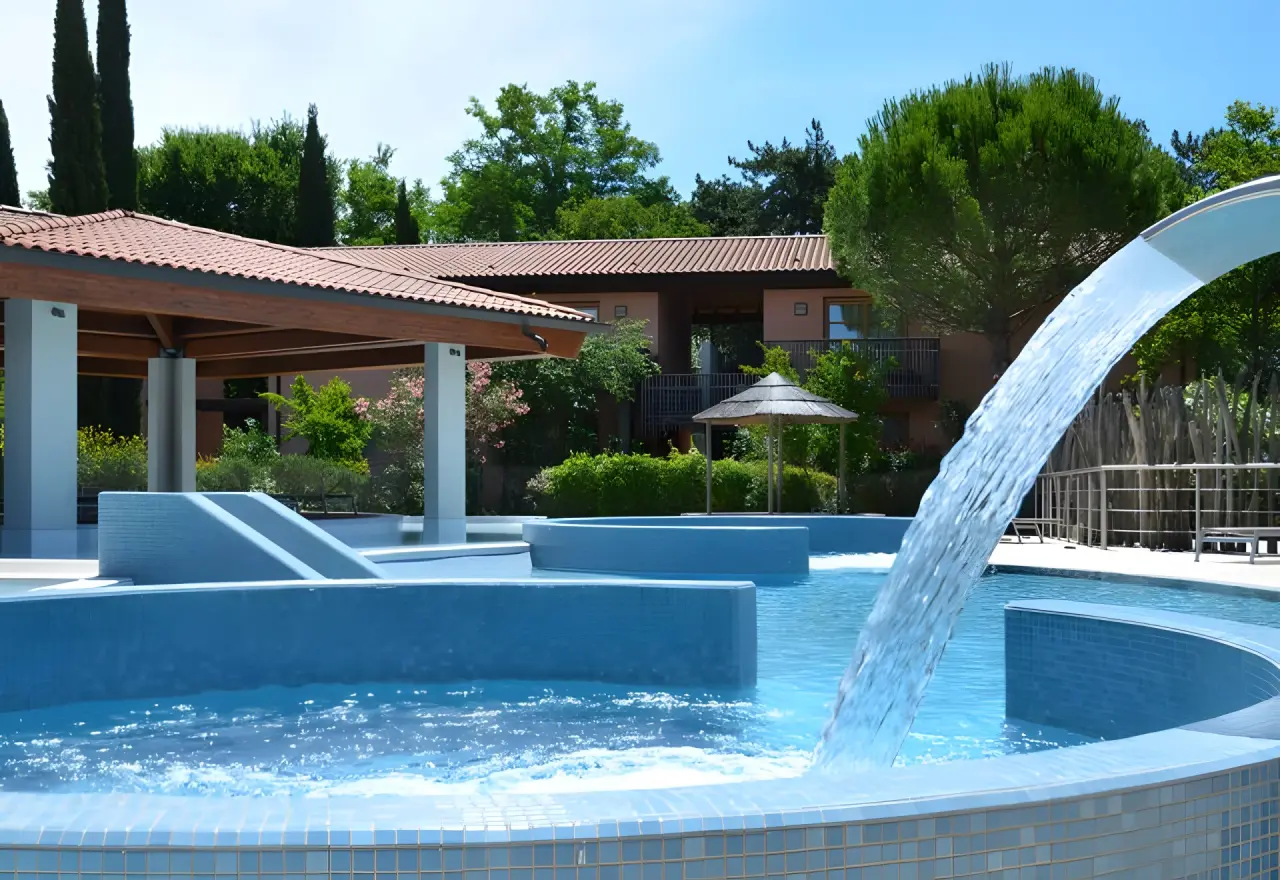 Green Village Resort 4 star Lignano in Lignano Sabbiadoro – Außenpool mit Wasserspielen und Hotelgebäude | Wellnesshotel Adria