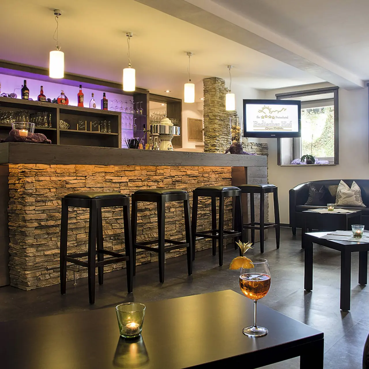 Hotel Badischer Hof in Biberach – Gemütliche Hotelbar mit Steinwand und Beleuchtung | Wellnesshotel Baden-Württemberg