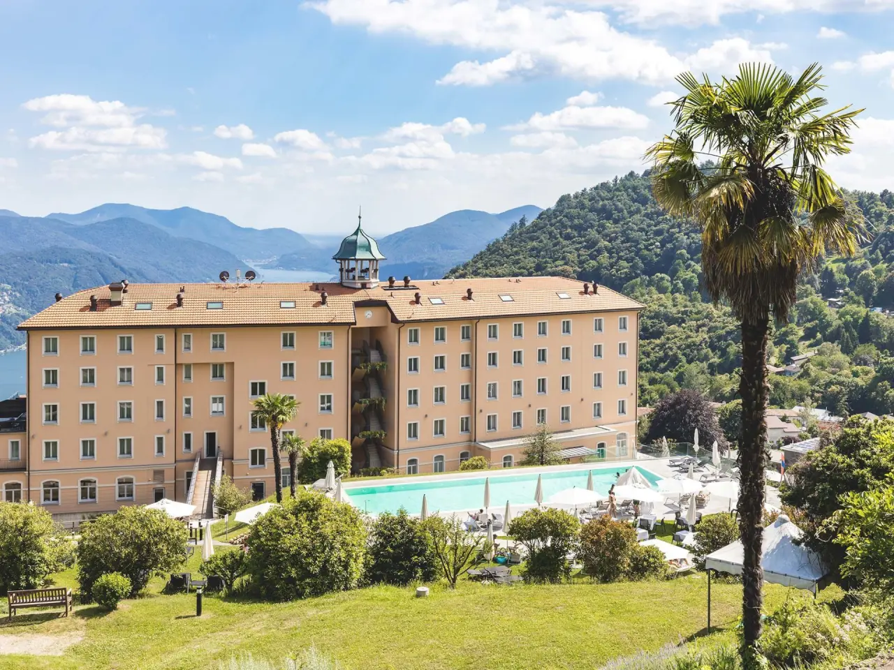 Kurhaus Cademario in Cademario – Hotelgebäude mit Außenpool und Bergblick | Wellnesshotel Tessin