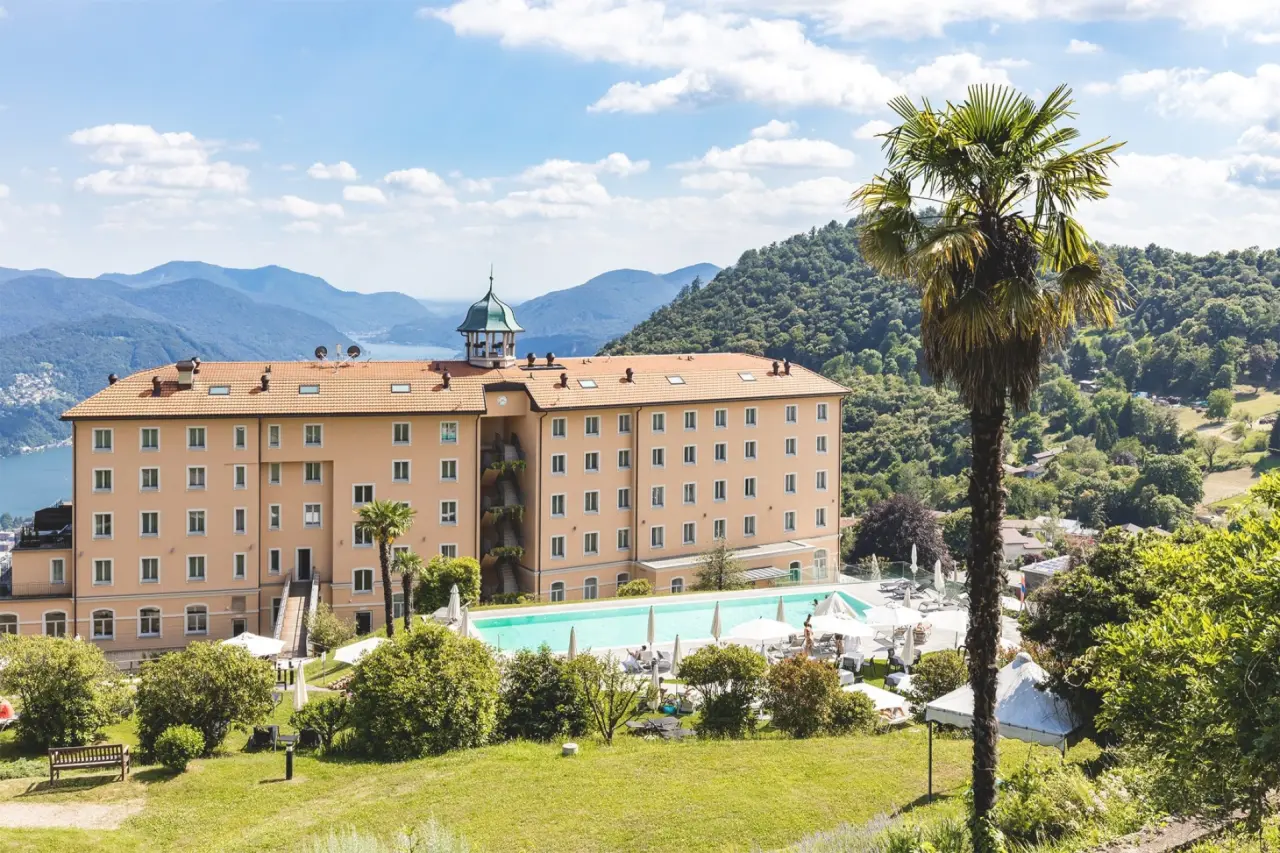 Kurhaus Cademario in Cademario – Außenansicht des Hotels mit Pool und Bergpanorama | Wellnesshotel Tessin