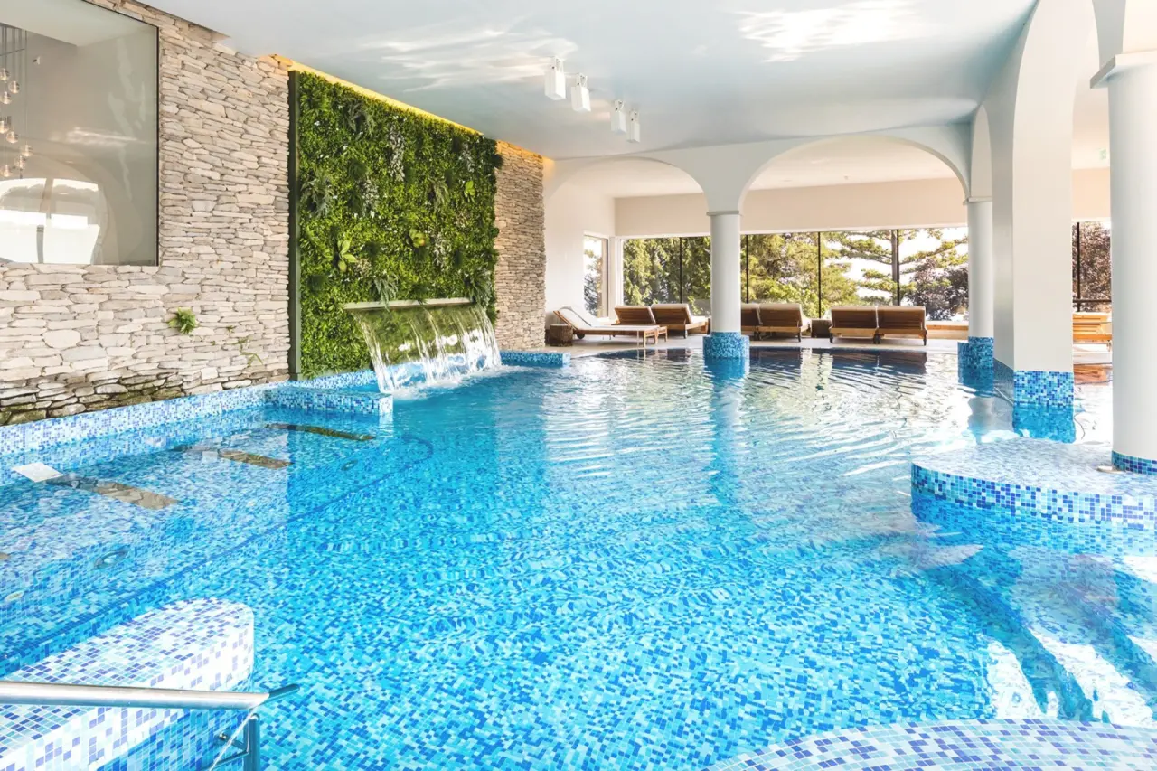 Kurhaus Cademario in Cademario – Moderner Innenpool mit Wasserfall und Grünwand | Wellnesshotel Tessin