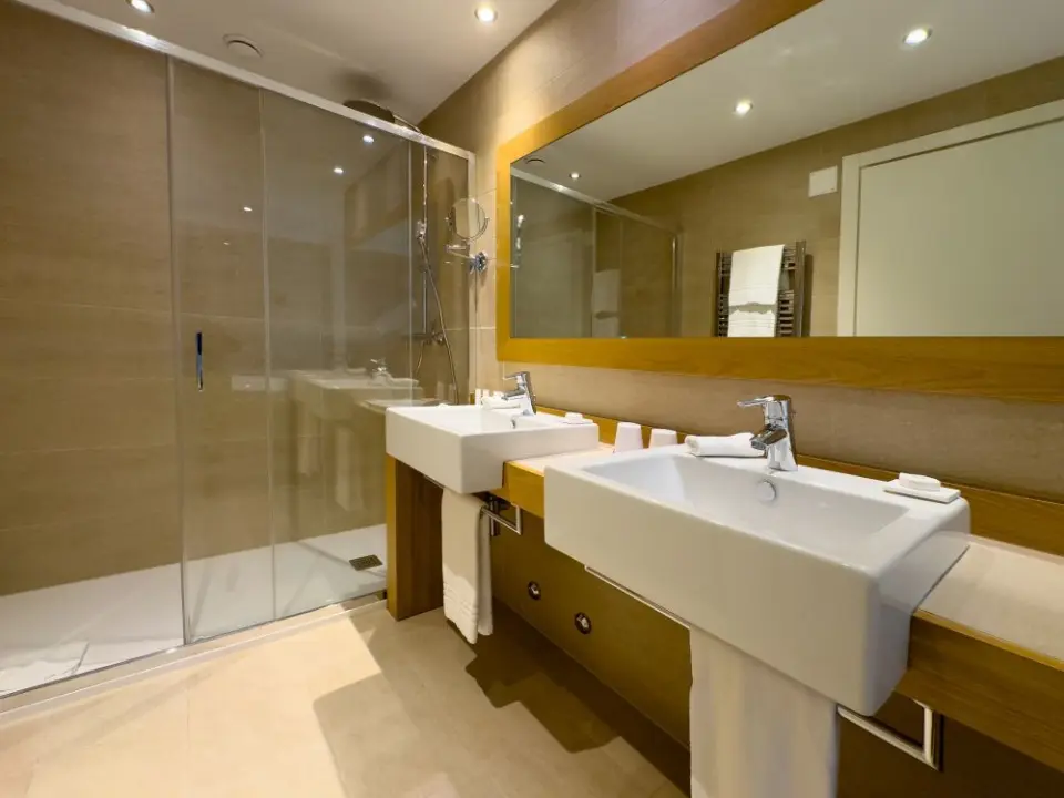 Kurhaus Cademario in Cademario – Modernes Badezimmer mit Doppelwaschbecken und Dusche | Wellnesshotel Tessin
