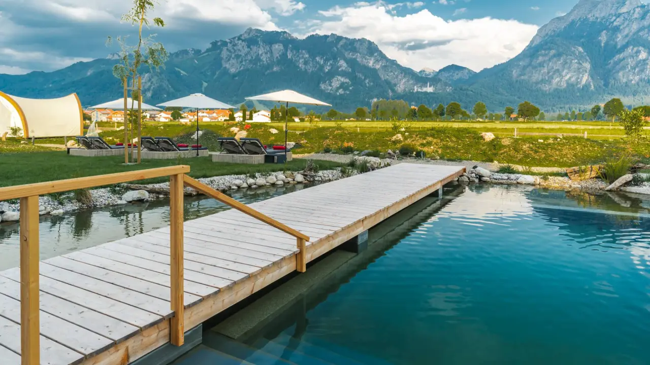 Das Rübezahl in Schwangau – Naturbadeteich mit Holzsteg und Alpenpanorama | Wellnesshotel Allgäu