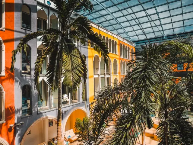 Hotel Victory Therme Erding in Erding – Mediterrane Hotelhalle mit Palmen und Glasdach | Wellnesshotel Bayern