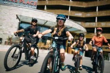 Peaks Place Apartment-Hotel & Spa in Laax – Familie auf Mountainbikes vor dem Hotel | Wellnesshotel Graubünden