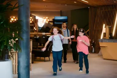 Peaks Place Apartment-Hotel & Spa in Laax – Familie betritt die moderne Hotellobby | Wellnesshotel Graubünden