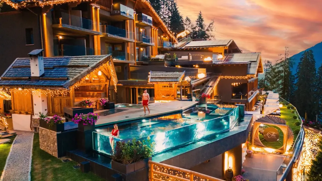 Chalet Al Foss Alp Resort in Pejo – Hotelanlage mit Infinity-Pool bei Sonnenuntergang | Wellnesshotel Trentino