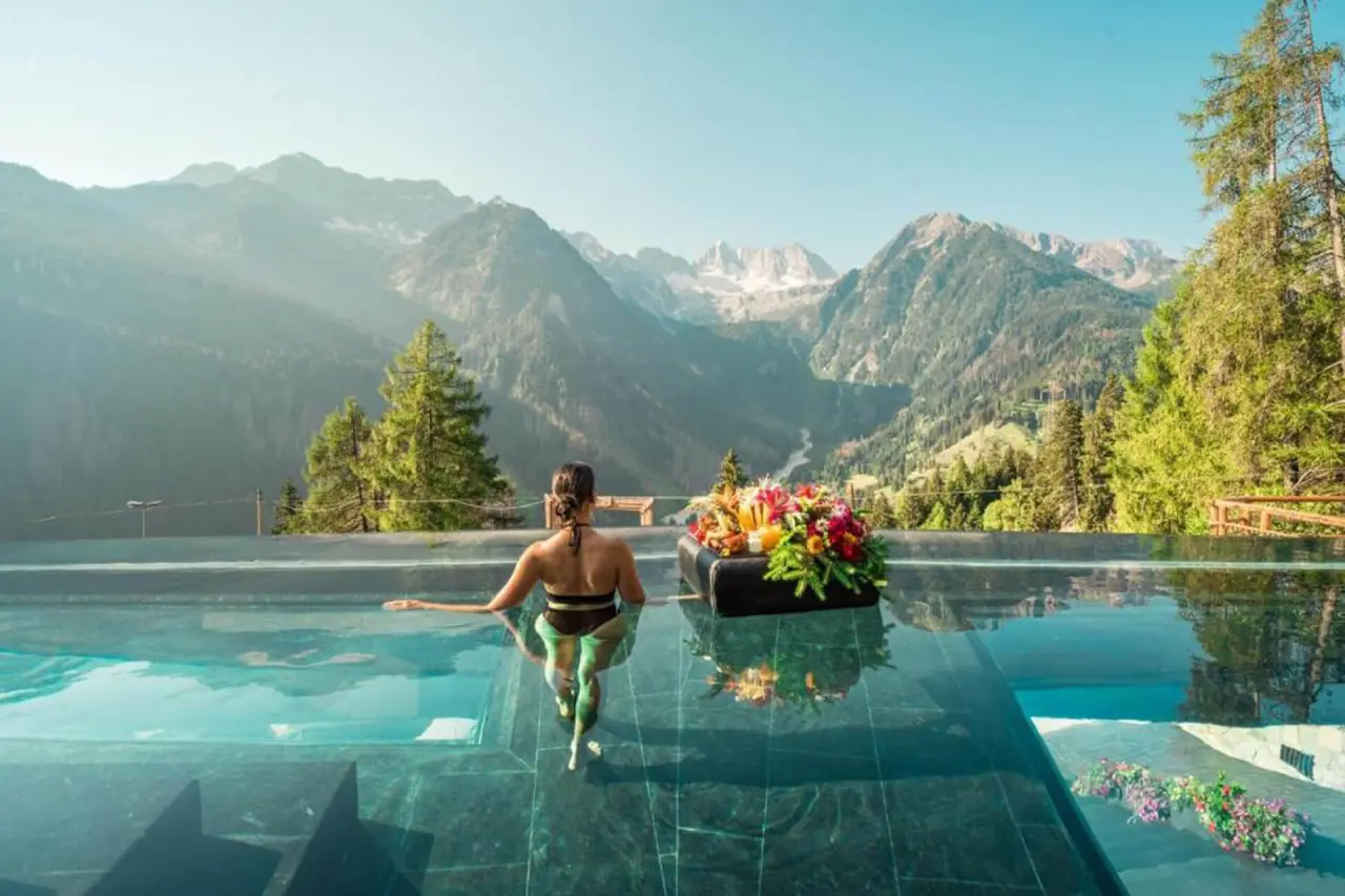 Chalet Al Foss Alp Resort in Pejo – Frau im Infinity-Pool mit atemberaubendem Bergpanorama | Wellnesshotel Trentino