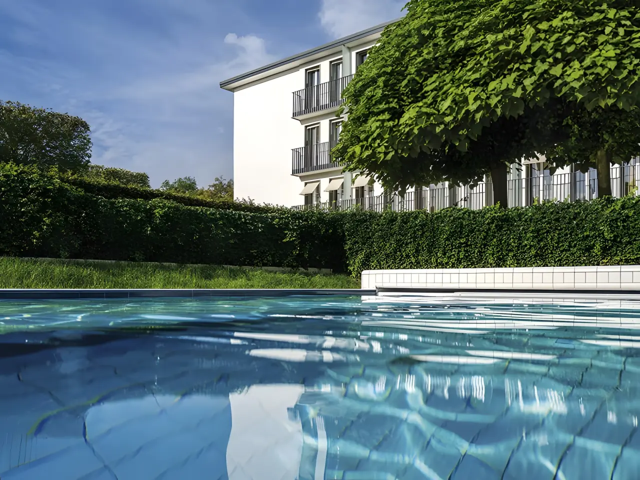 Parkhotel Bremen in Bremen – Außenpool mit Hotelgebäude und Grünanlage | Wellnesshotel Norddeutschland