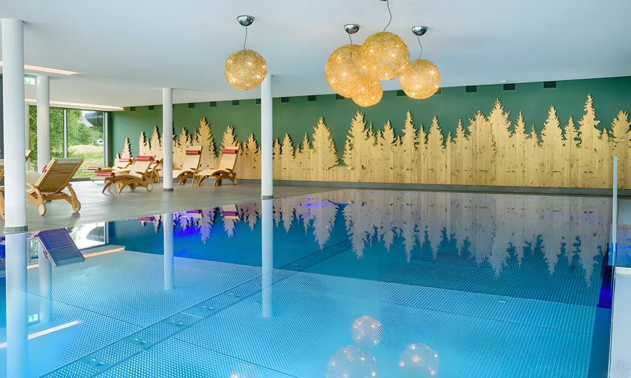 Hotel Thomahof in Hinterzarten – Innenpool mit Wald-Dekoration und Liegebereich | Wellnesshotel Schwarzwald