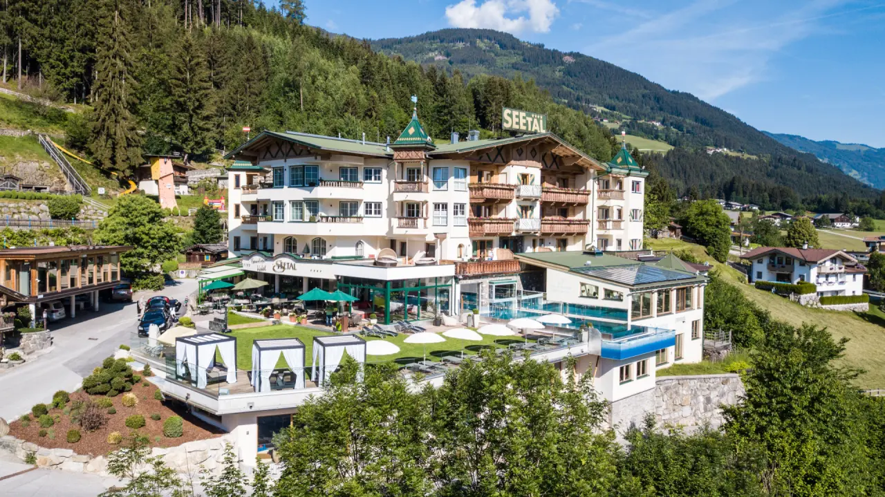 Alpin Family Resort Seetal****s in Kaltenbach – Hotelansicht mit Außenbereich und Bergen | Wellnesshotel Zillertal