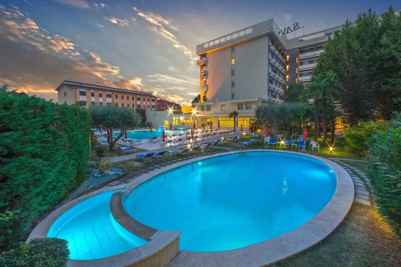 Hotel Savoia Thermae & SPA in Abano Terme – Außenansicht mit beleuchtetem Poolbereich bei Sonnenuntergang | Wellnesshotel Venetien