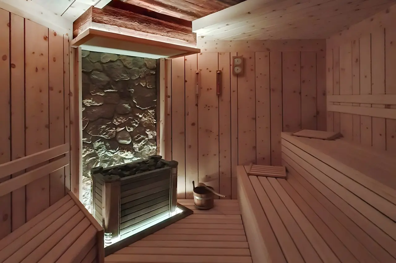 Cirelle Suite Hotel & Spa in Canazei – Moderne Holzsauna mit Steinwand und indirekter Beleuchtung | Wellnesshotel Dolomiten